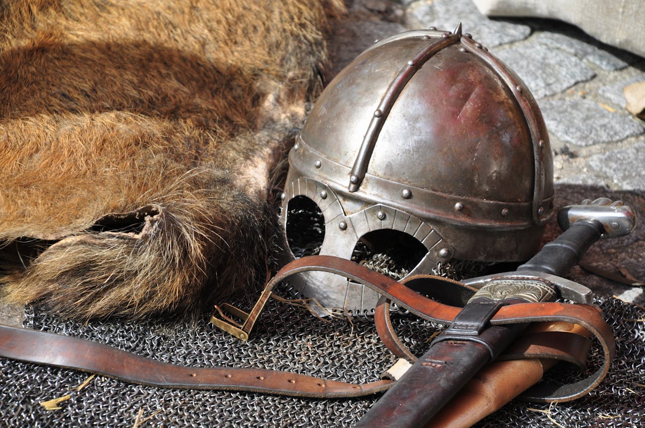 Close-up of medieval armor, helmet, and sword in a classic setting.